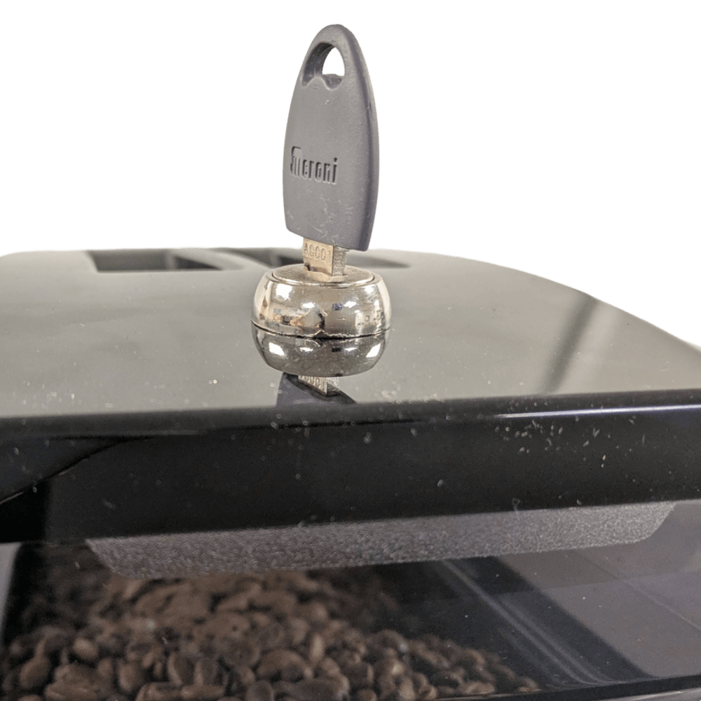 Close-up of OBL1 coffee machine canister lock with key on top of the bean hopper, highlighting security feature