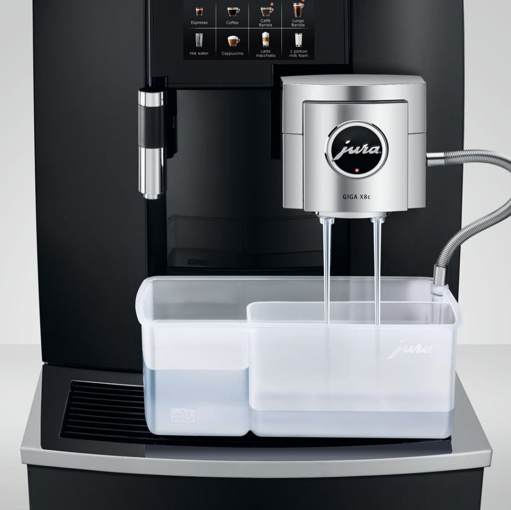 Close-up view of OBL2 Jura Giga X8C coffee machine's water tank and milk system attachment during cleaning cycle on a white background