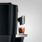 Left view of OBM3  Jura X10 coffee machine dispensing a glass of iced coffee into a clear cup on a light gray background